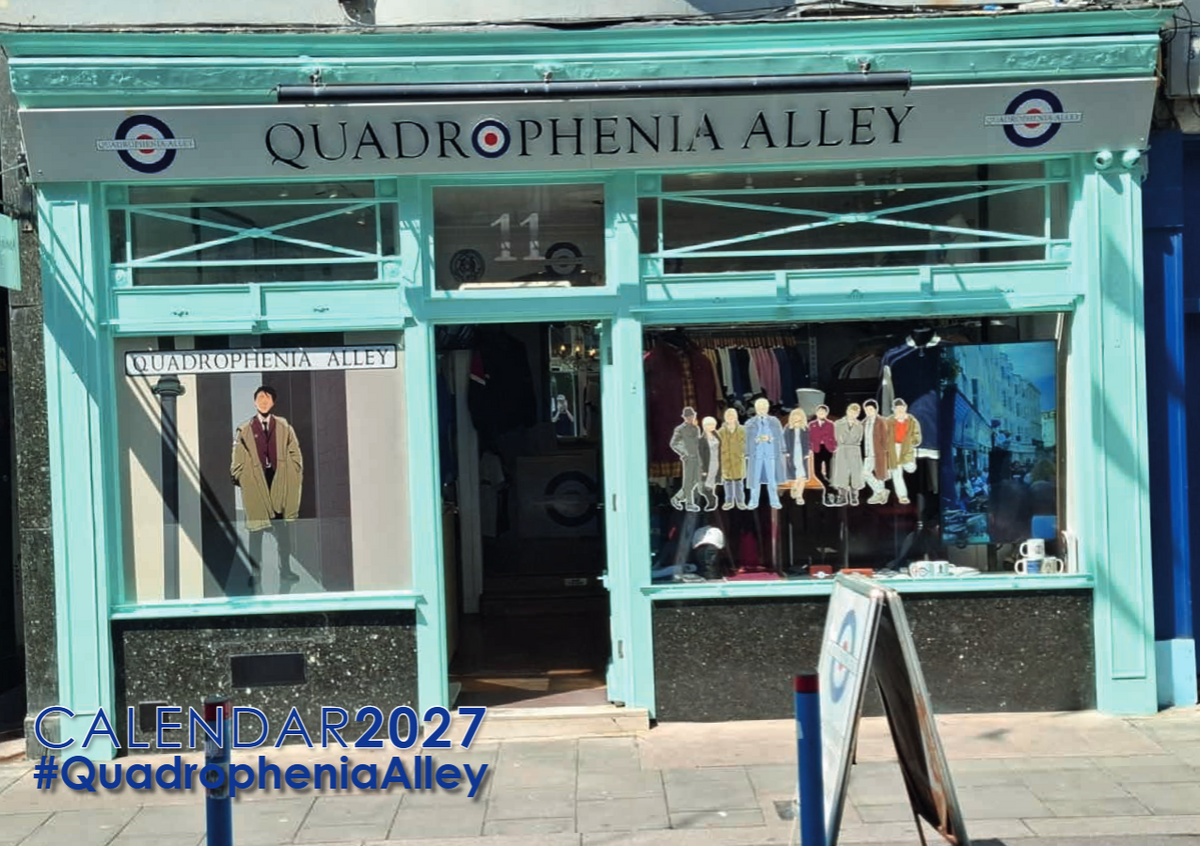 The storefront of Quadrophenia Alley, featuring a mint green painted facade and a large sign above the entrance. Mannequins and clothing are displayed in the windows, and a sidewalk A-frame sign is visible in the foreground.
